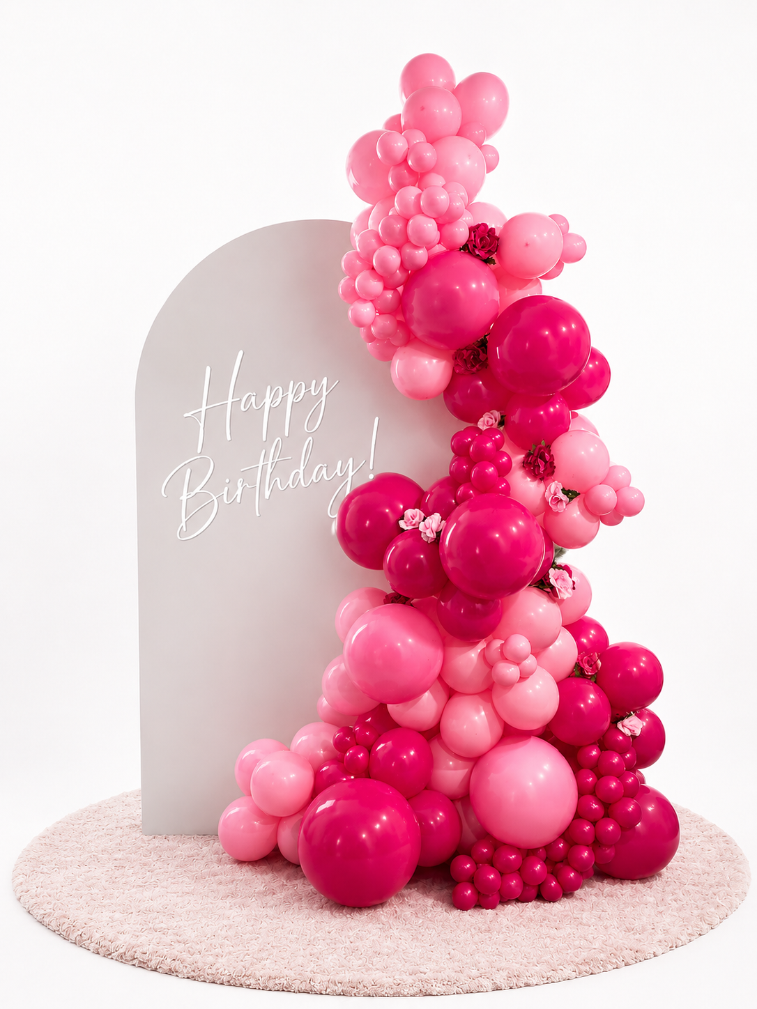 Luxury blush birthday balloon backdrop with pink organic garland and white arch in Tampa