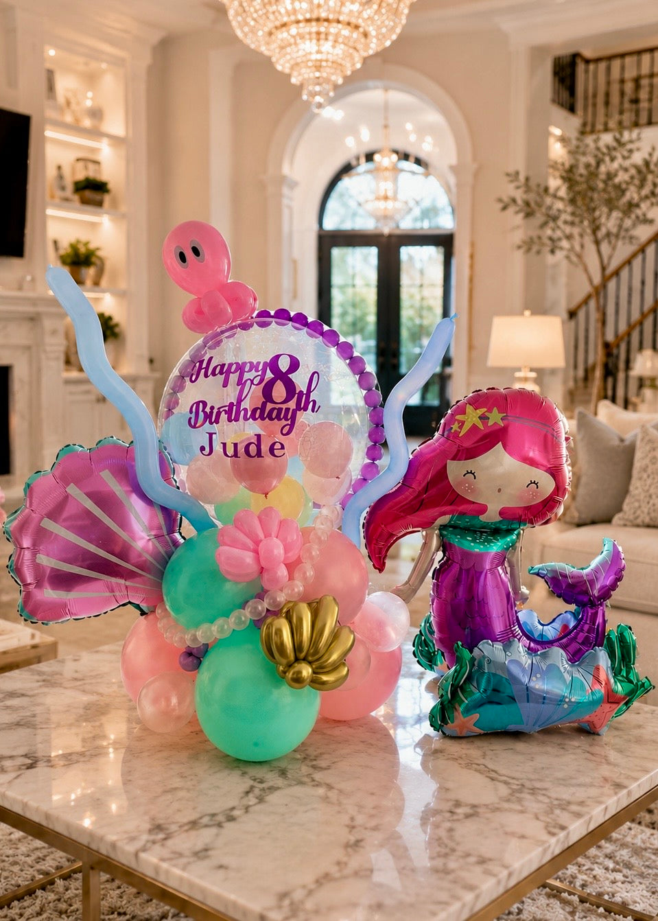 Luxury personalized mermaid birthday balloon arrangement with bubble balloon, pastel balloons, and ocean-themed styling in elegant living room setting.
