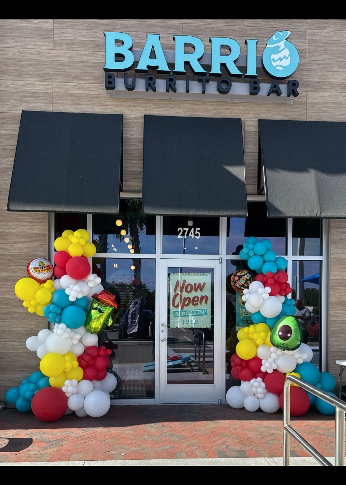 Colorful taco themed balloon garland for restaurant grand opening, Cinco de Mayo inspired balloon entrance decor , Restaurant entrance decorated with vibrant fiesta balloons