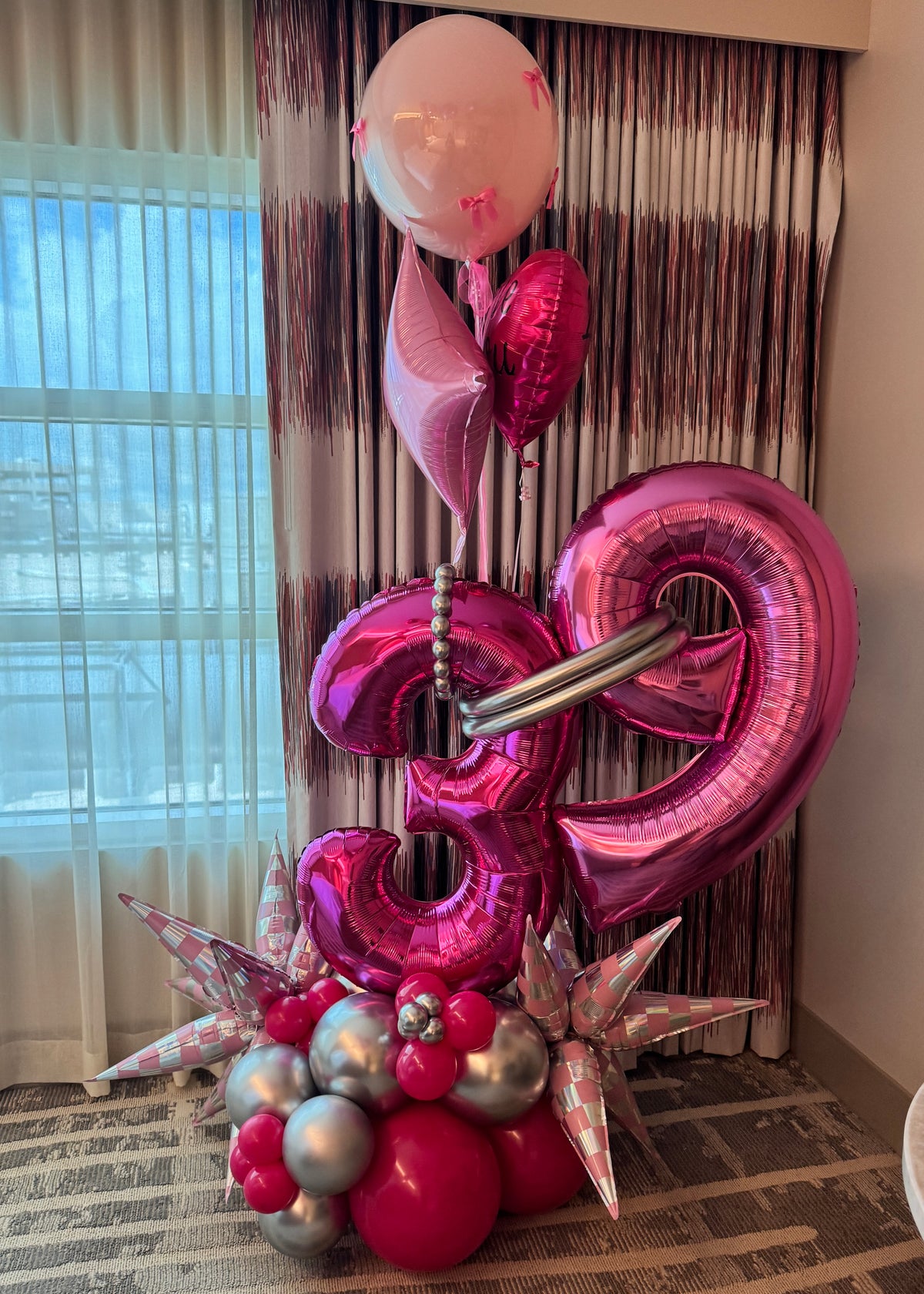 Luxury pink and silver double number birthday balloon arrangement with personalized helium balloons and organic balloon base in Tampa