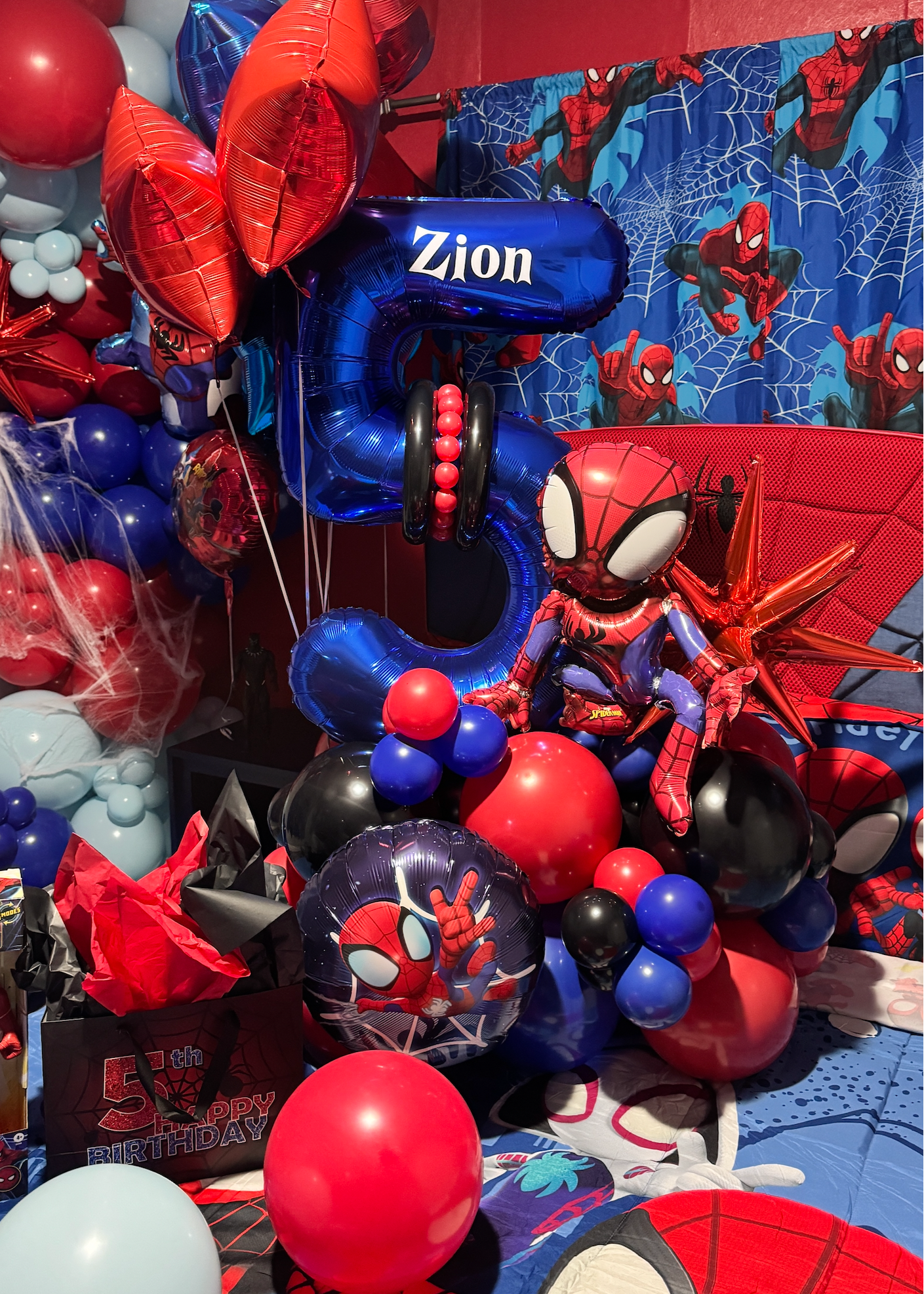 Spider-Man inspired birthday bedroom decoration with red and blue balloon garlands, helium balloons, personalized number balloon and kids birthday room setup in Tampa
