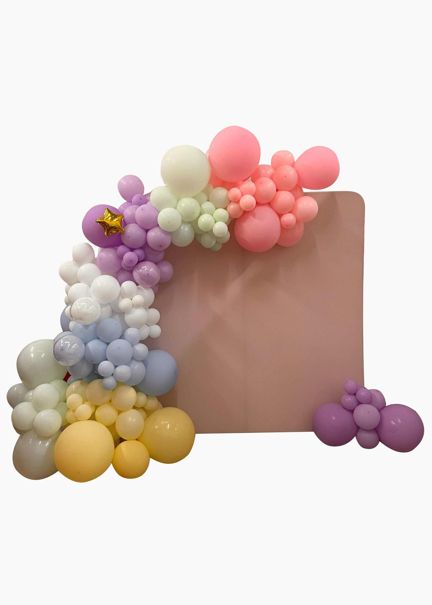 Pastel balloon garland in soft colors arranged around a pink backdrop for celebrations
