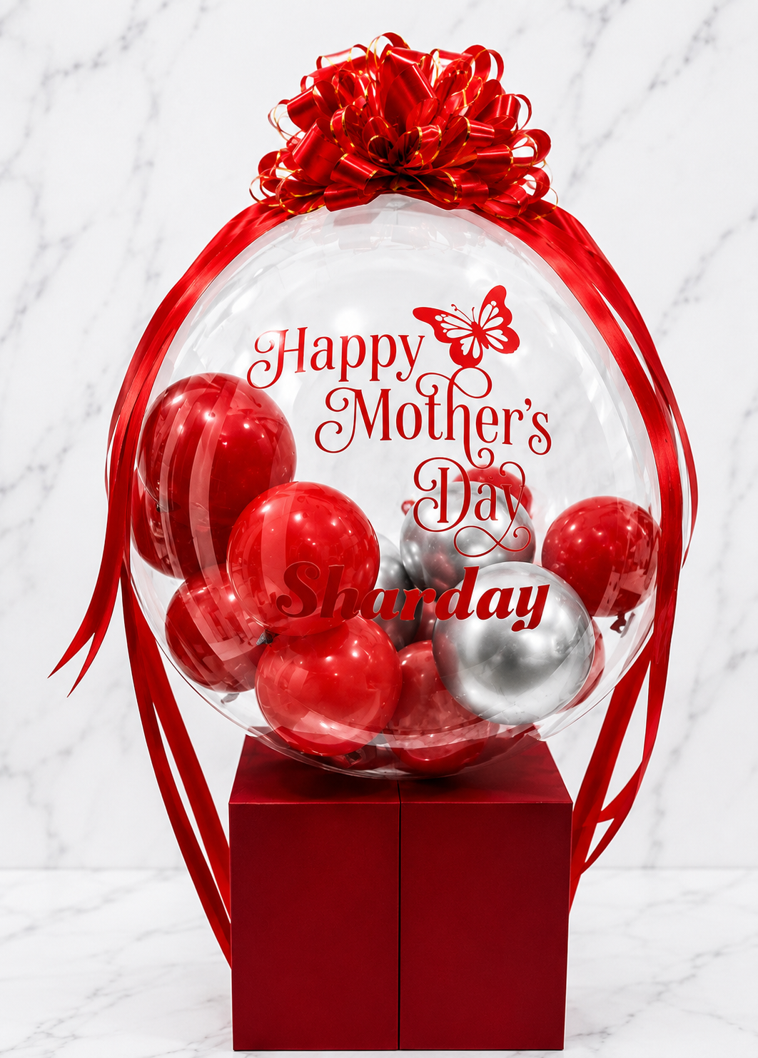 Luxury red and silver personalized Mother’s Day bubble balloon arrangement with custom name and satin bow on gift box base.