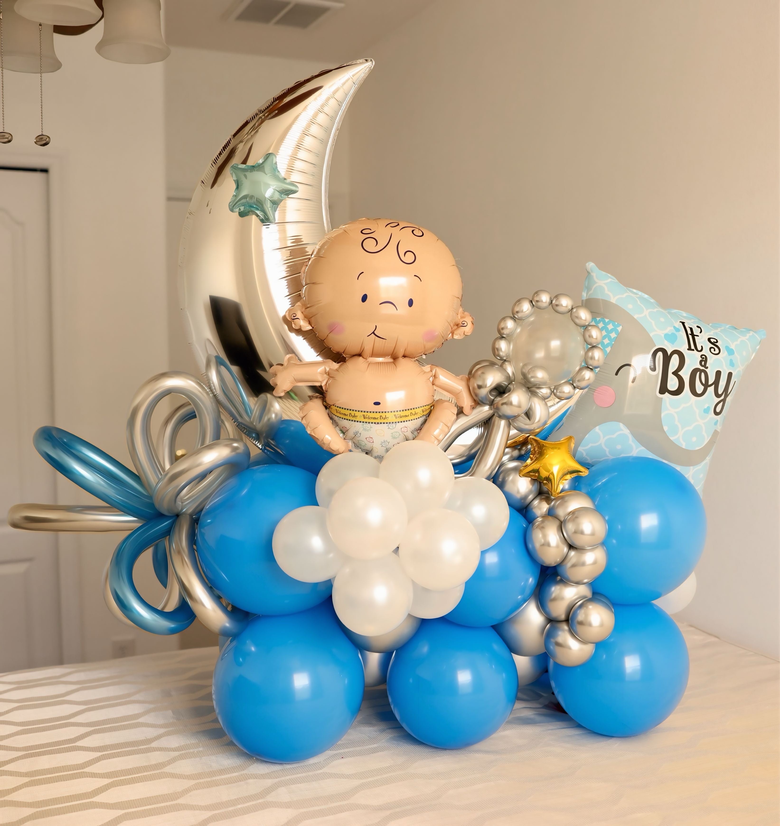 Balloon arrangement with baby figure, moon, and &