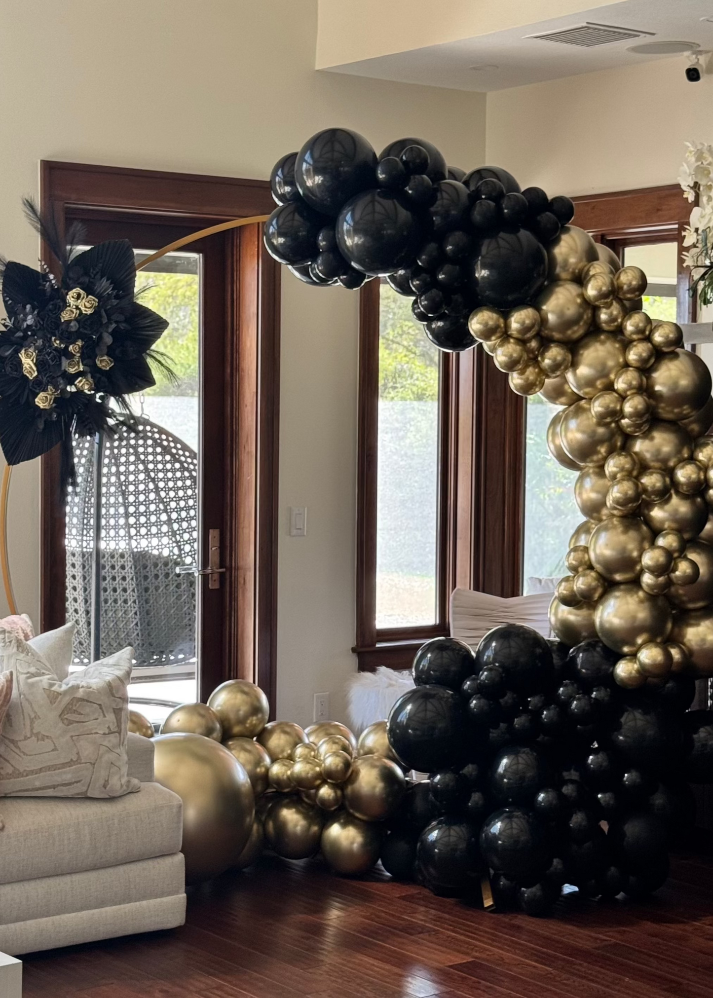 Black & Gold Balloon Garland On Circle Arch with Boho Flower Arrangement