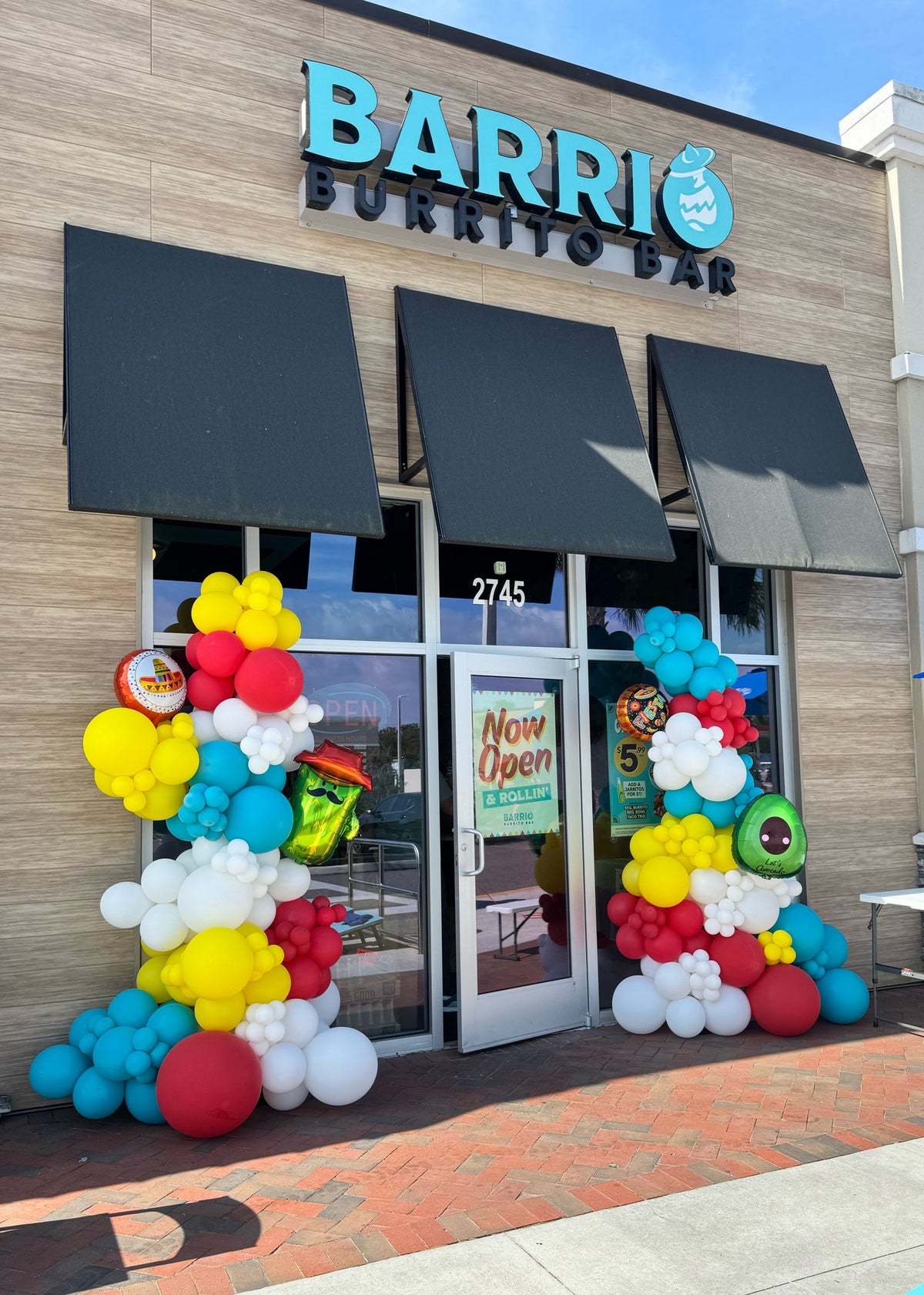 Colorful taco themed balloon garland for restaurant grand opening, Cinco de Mayo inspired balloon entrance decor , Restaurant entrance decorated with vibrant fiesta balloons