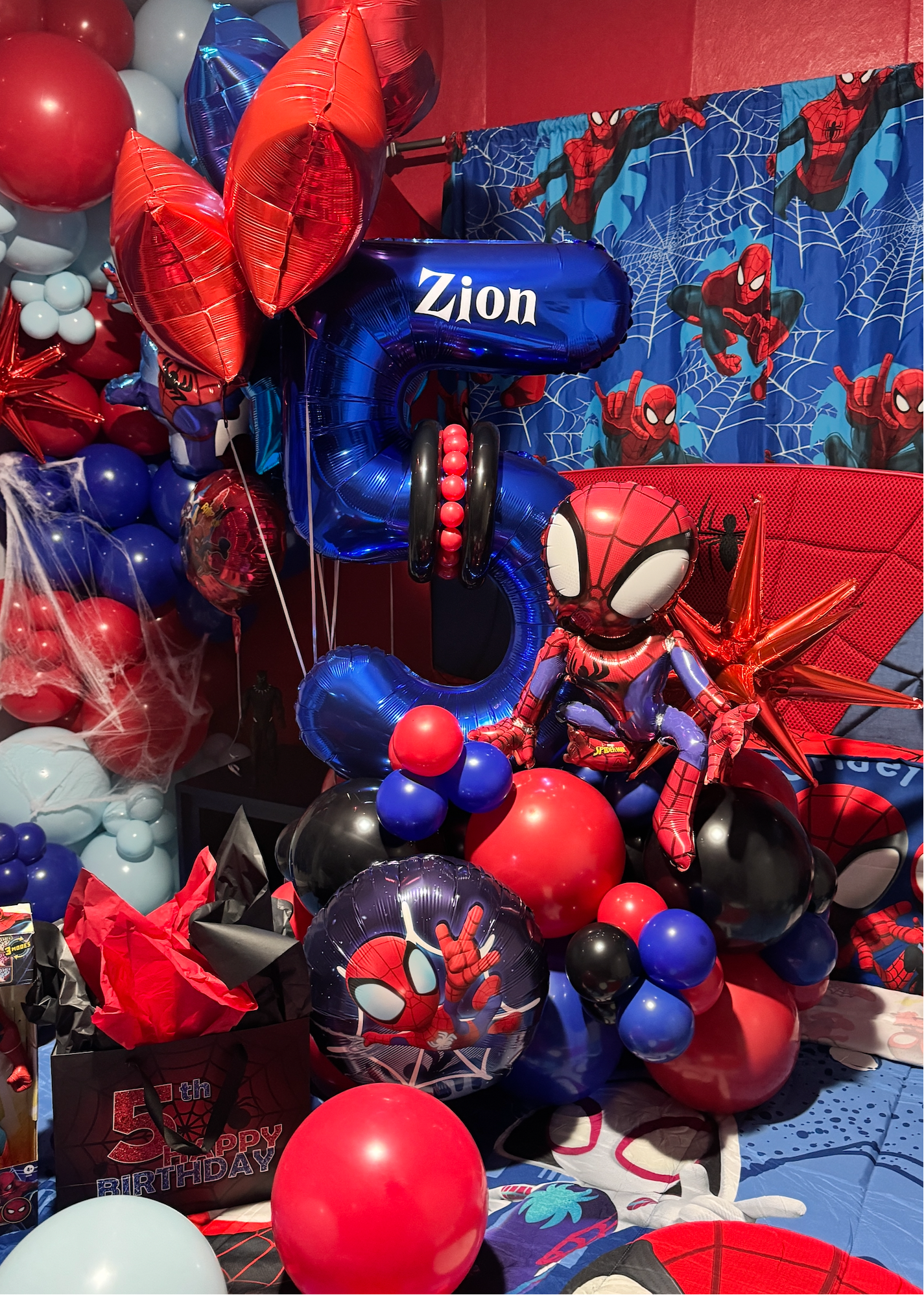 Spider-Man inspired birthday bedroom decoration with red and blue balloon garlands, helium balloons, personalized number balloon and kids birthday room setup in Tampa