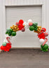 Festive designer and theme balloon arch with red, green, white, and gold balloons, candy cane decorations for event celebration