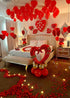 Romantic hotel room decorated with red heart-shaped balloons, rose petals, and LED lights for Crazy In Love Package celebration